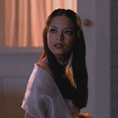 a woman with long hair standing in a room