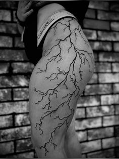 a woman's leg with lightning tattoo on it, and the word lightning written in black