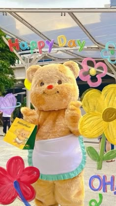 a large teddy bear standing in front of a happy day sign