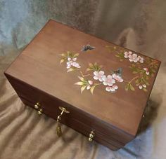 a wooden box with flowers painted on it