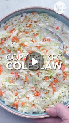 a bowl filled with coleslaw and carrots on top of a white table