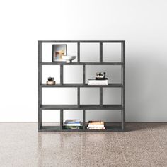 a book shelf sitting on top of a floor next to a vase and bookshelf