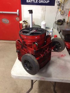 a red engine sitting on top of a table in a garage next to a sign