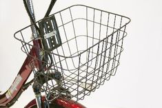 a red bike with a basket on the front and back tire, against a white background