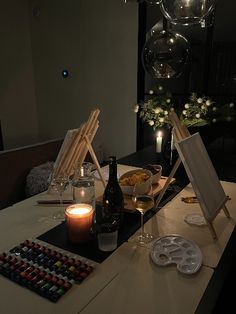 a table with candles, wine glasses and pictures on it