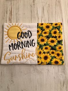 a patch with the words good morning sunshine and sunflowers on it, sitting on a wooden surface