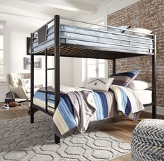 a bunk bed with blue and white striped bedspread in a living room next to a brick wall