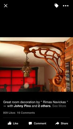 a wooden shelf with a light fixture hanging from it's side in front of a red wall