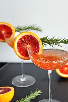 two grapefruit cocktails garnished with rosemary