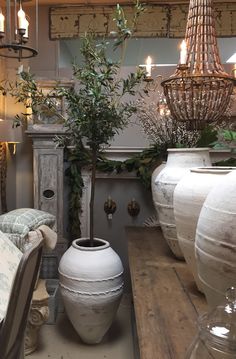 an arrangement of vases sitting on top of a wooden table next to a couch