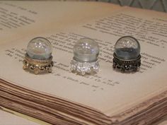 three snow globes sitting on top of an open book