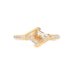 a yellow gold ring with an octagonal cut diamond and baguets on the side