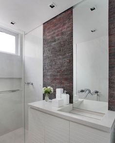 a bathroom with two sinks and a brick wall