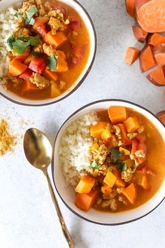 two bowls filled with rice and vegetables on top of a white counter next to sliced carrots