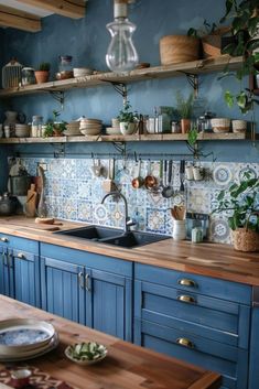 a kitchen with blue cabinets and shelves filled with pots, pans and other items