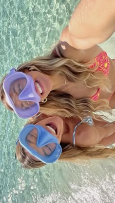 two women in bikinis standing next to each other near the water with snorkelets on their heads