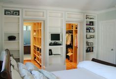 an image of a bedroom with closets on the wall and bed in the room