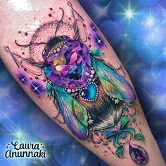 a colorful tattoo with an image of a dream catcher on the leg and stars in the background