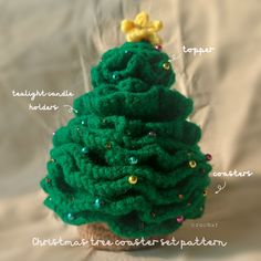 a crocheted christmas tree sitting on top of a white sheet with words written below it