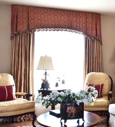 a living room with two chairs and a coffee table in front of a large window