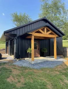 a small black building with a wooden roof