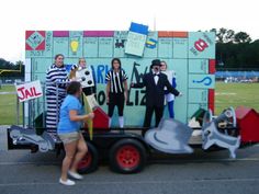 a group of people dressed up in costumes standing next to a trailer with an advertisement on it