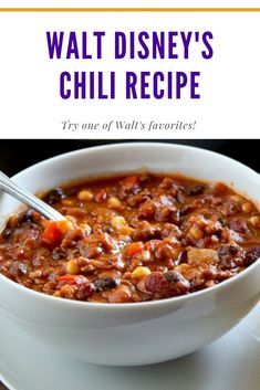 a white bowl filled with chili and beans on top of a table next to a plate