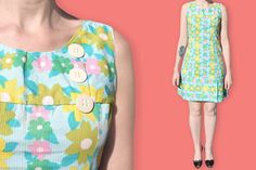 "60s Flower Print Babydoll Dress - Fitted Sleeveless Floral Mod Dress - Multicolor Bold Flower Scooter Dress - Mini Clueless Daisies Dress S P E C I F I C S : ♦ Sleeveless ♦ Scooped neckline ♦ Princess seams on front for a fitted silhouette ♦ Chest yoke ♦ 3 big cream decorative buttons on the left side  ♦ Bottom yoke with a pleat on the left side ♦ 1 metallic zip on the left side ♦ Bucolic print made of bold green, yellow and pink daisies on a blue backgrounf M E A S U R E M E N T S : ♦ Shoulder Mod Sleeveless Dresses With Buttons, Retro Sleeveless Dress With Floral Print For Spring, Retro Multicolor Sleeveless Dress For Spring, Retro Sleeveless Dress With Buttons, Spring Mod Dresses With Buttons, Summer Mod Dress With Buttons, Mod Style Summer Dress With Buttons, Vintage Sleeveless Floral Dress For Spring, Retro A-line Sleeveless Dress For Spring