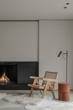 a chair sitting in front of a fire place next to a floor lamp and rug