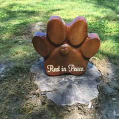 a wooden carving of a dog's paw with the words rest in peace on it