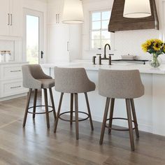 three stools sit at the center of a kitchen island