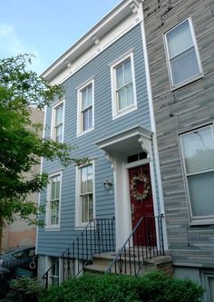 a blue house with a wreath on the door and steps leading up to it's entrance