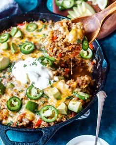 a skillet filled with mexican food and topped with sour cream