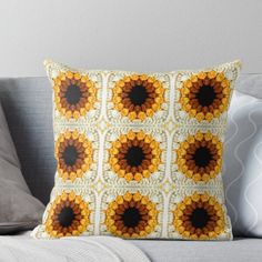 an orange and yellow sunflower pattern on a white background throw pillow sitting on top of a couch