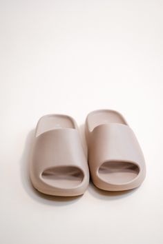 a pair of pink slippers sitting on top of a white floor next to each other