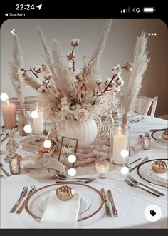 a table set with plates, silverware and candles