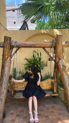 a woman sitting on a wooden swing