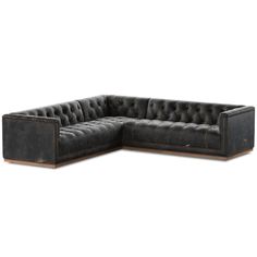 a black leather sectional sofa with wooden legs and tufted upholstered backrests