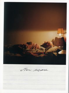 a man laying in bed under a lamp