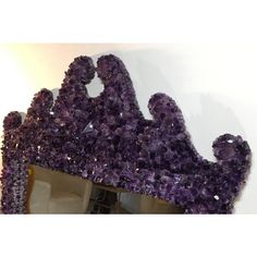 a mirror with purple crystals on it in front of a wall