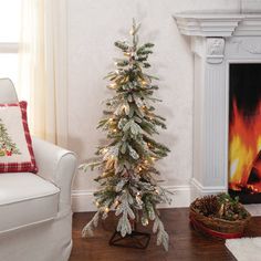 a decorated christmas tree in the corner of a living room next to a fire place