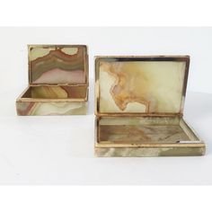 two boxes with marble in them sitting on a white surface, one is open and the other is closed