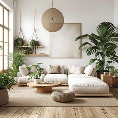 a living room filled with lots of plants next to a large white couch and coffee table