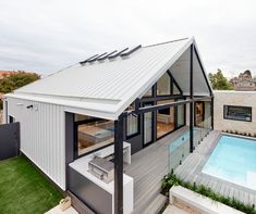 a house with a swimming pool in the yard and a covered patio next to it