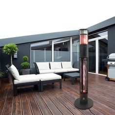 an outdoor living area with couches and a heater on top of the deck