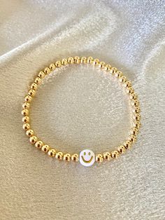 This listing is for 1 bracelet | 4mm 14K gold-filled beads strung on elastic stretch cord, accented with a white/gold smiley face acrylic bead. Lizzo Concert, Smiley Face Bracelet, Birthday Bracelet, Golden Birthday, Bead Bracelets, Seed Bead Bracelets, Bead Stringing, Acrylic Beads, Clay Beads