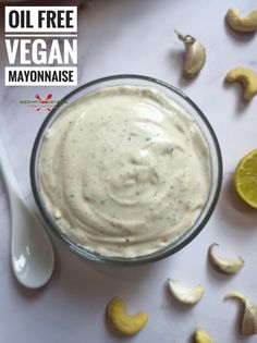 a glass bowl filled with mayonnaise next to sliced lemons and cashews