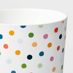 a white vase with multicolored polka dots on it