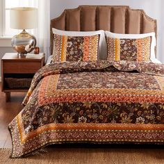 a bed with brown and orange bedspread in a bedroom