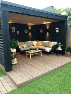 an outdoor living area with couches, tables and plants on the decking outside